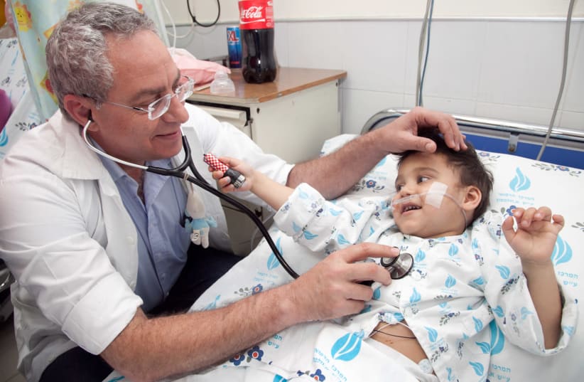 SACH courtesy photo shows Dr. Lior Sasson with child from Romania after undergoing surgery (photo credit: Courtesy)