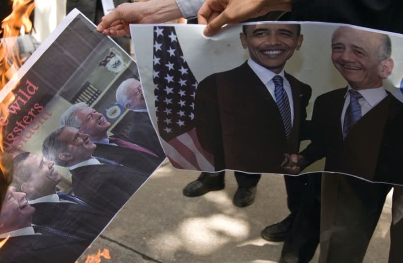 STUDENTS BURN a picture of former American presidents, along with another featuring Olmert (right) in front of the former US embassy in Tehran in 2009 (photo credit: REUTERS)