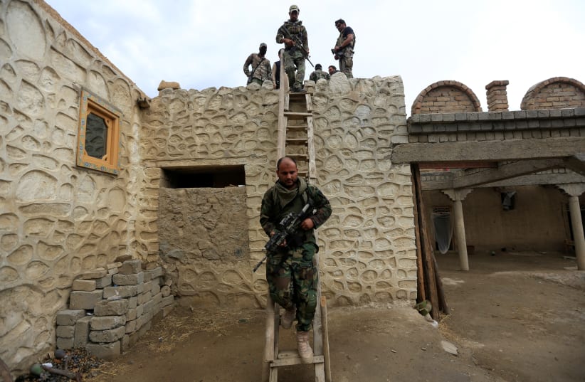 Afghan Special Forces walk down from a roof of a house which was used by suspected Islamic State militants at the site of a ''mother of all bombs'', that struck the Achin district of Afghanistan April 23, 2017. (photo credit: REUTERS/PARWIZ)