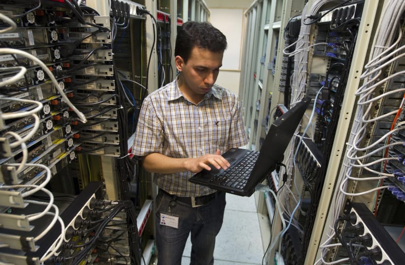 A computer engineer checks equipment at an internet service provider in Tehran February 15, 2011 (photo credit: CAREN FIROUZ / REUTERS)