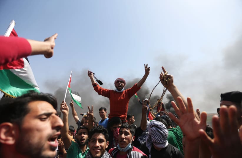 Palestinian demonstrators during a protest on the Israel-Gaza border east of the Jabalia refugee camp in the northern Gaza Strip on April 6, 2018. (photo credit: MOHAMMED ABED / AFP)