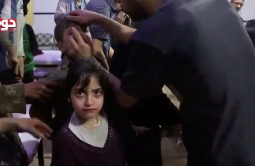 A girl looks on following alleged chemical weapons attack, in what is said to be Douma, Syria in this still image from video obtained by Reuters on April 8, 2018 (photo credit: WHITE HELMETS/REUTERS TV VIA REUTERS)