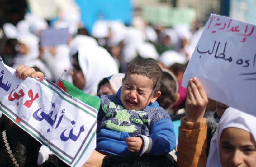 A PALESTINIAN BOY cries as students of United Nations-run schools take part in a protest against a US decision to cut aid, in Khan Yunis in the southern Gaza Strip, February 2017 (photo credit: REUTERS)