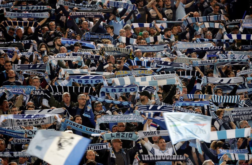 Lazio fans hold up scarves before their team's match against rivals AS Roma, April 5, 2018 (photo credit: REUTERS/MAX ROSSI)