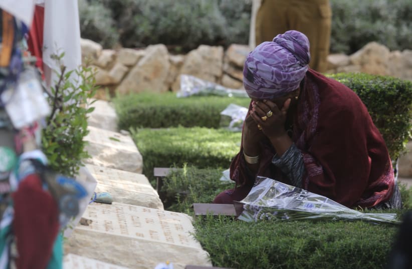 A woman cries while sitting near a grave on Mount Herzl during Remembrance Day on April 18th, 2018. (photo credit: MARC ISRAEL SELLEM/THE JERUSALEM POST)