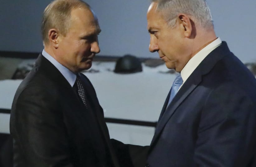 Russian President Vladimir Putin and Israeli Prime Minister Benjamin Netanyahu shake hands as they attend an event marking International Holocaust Remembrance Day and the 75th anniversary of the breakthrough of the Nazi siege of Leningrad in World War II, at the Jewish Museum and Tolerance Center in (photo credit: REUTERS/MAXIM SHEMETOV)