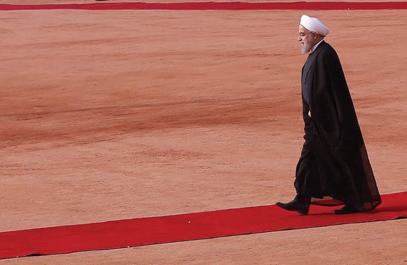Iranian President Hassan Rouhani walks on a red carpet in Tehran (photo credit: REUTERS)