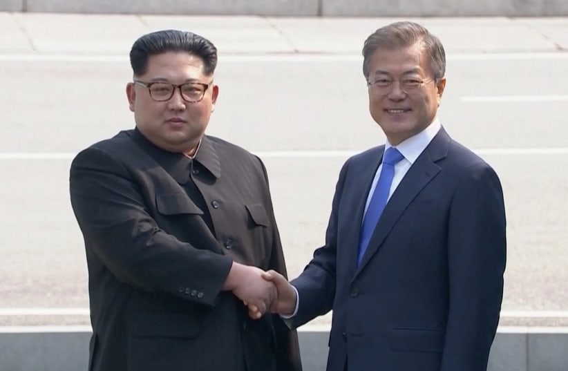 North Korean leader Kim Jong Un shakes hands with South Korean President Moon Jae-in as both of them arrive for the inter-Korean summit at the truce village of Panmunjom, April 27, 2018 (photo credit: HOST BROADCASTER VIA REUTERS TV)