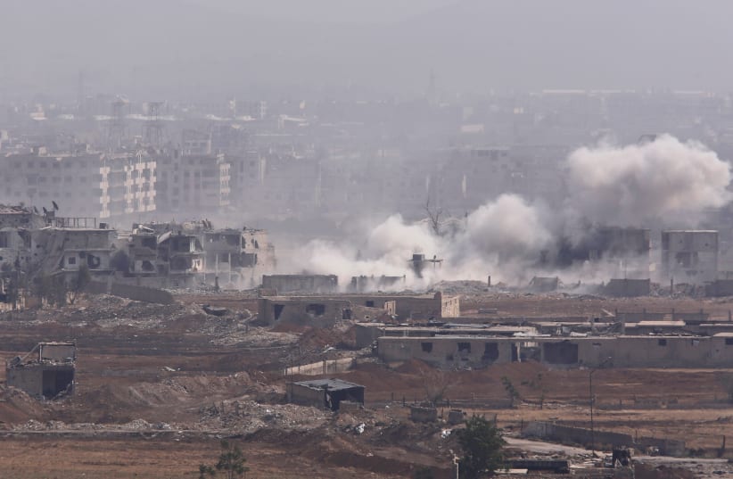 Smoke rises from the Yarmouk Palestinian camp in Damascus, Syria April 28, 2018. (photo credit: OMAR SANADIKI/REUTERS)