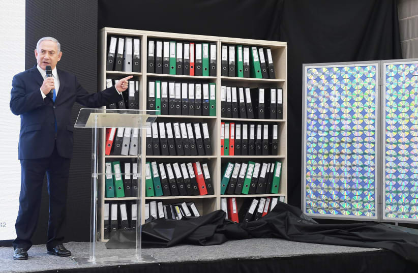 Prime Minister Benjamin Netanahu points to files containing copys of Iranian data during a televised speech on April 30th, 2018. (photo credit: GPO/AMOS BEN GERSHOM)