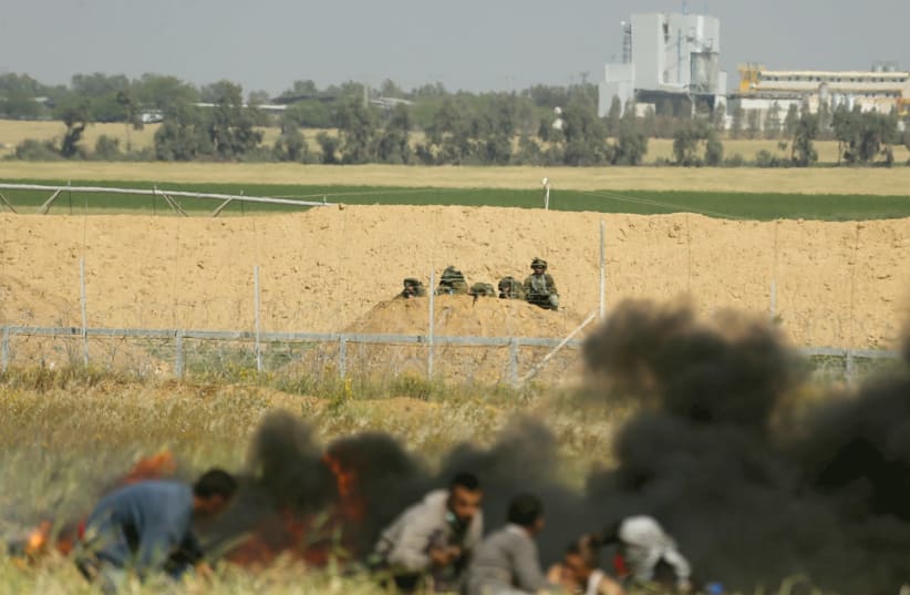 PALESTINIANS AT the Gaza border fence. (photo credit: REUTERS)