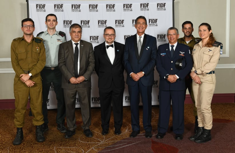 FIDF National Director and CEO Maj. Gen. (Res.) Meir Klifi-Amir (third from left), FIDF National Chairman Arthur Stark (fourth from left), FIDF National President Peter Weintraub (fifth from left), and former Israeli Air Force chief Maj. Gen. Amir Eshel (sixth from left) with IDF soldiers at the FID (photo credit: SHAHAR AZRAN)