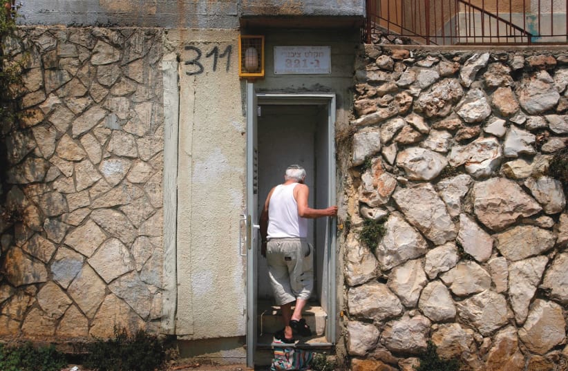 A man in Kiryat Shmona ducks into a bomb shelter in 2006 (photo credit: REUTERS)