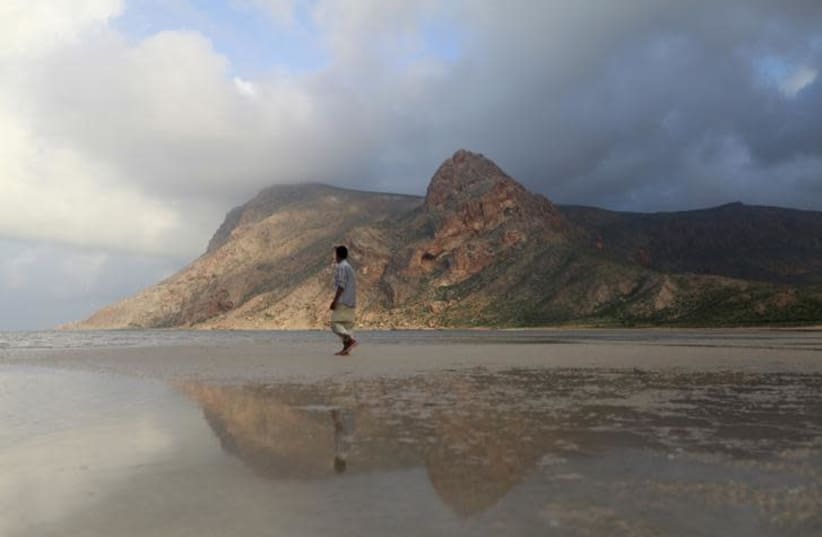 A local guide walks on the approach to Ditwa lagoon and beach near the port of Qalensiya, the second biggest town on Yemen's Socotra island November 21, 2013. (photo credit: MOHAMED AL-SAYAGHI / REUTERS)