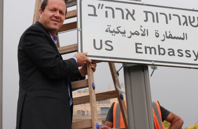 Jerusalem Mayor Nir Barkat installs a road sign directing to the US embassy, in the area of the U.S. consulate in Jerusalem, May 7, 2018 (photo credit: JERUSALEM MUNICIPALITY)