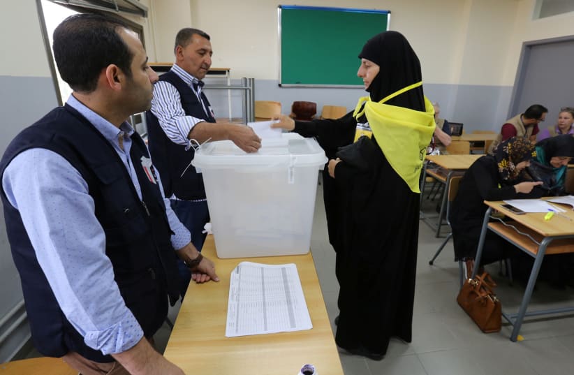 A woman supporter of Hezbollah casts her vote at a polling station during the parliamentary election in Tibnin, South Lebanon, May 6, 2018.  (photo credit: REUTERS/AZIZ TAHER)