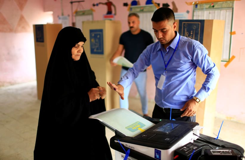 An Iraqi woman casts her vote at a polling station during the parliamentary election in Baghdad, Iraq May 12, 2018.  (photo credit: THAIER AL-SUDANI/REUTERS)