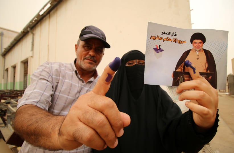 Iraqi people show their ink-stained fingers after casting their votes at a polling station during the parliamentary election in Basra, Iraq May 12, 2018. (photo credit: ESSAM AL-SUDANI/ REUTERS)