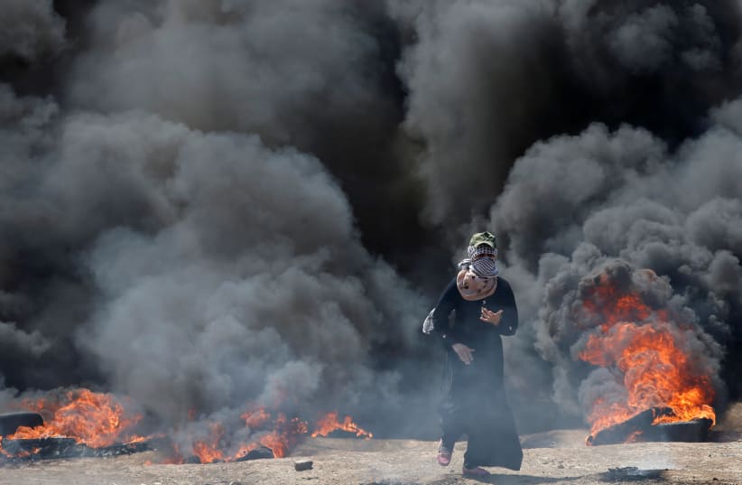 A female Palestinian demonstrator during a protest against US embassy move to Jerusalem, at the Israel-Gaza border, east of Gaza City May 14, 2018 (photo credit: MOHAMMED SALEM/REUTERS)