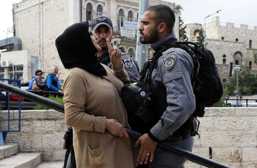 DATE IMPORTED: May 14, 2018 An Israeli police officer argues with a Palestinian woman outside Jerusalem's Old City's Damascus Gate, May 13, 2018. (photo credit: REUTERS/AMMAR AWAD)