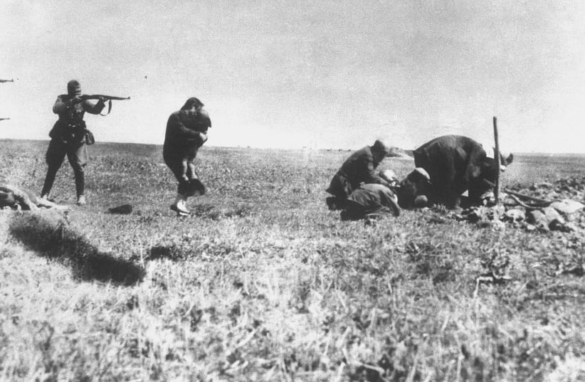 EINSATZGRUPPEN OFFICERS murder Jews in Ivanhorod, Ukraine, in 1942 (photo credit: Wikimedia Commons)
