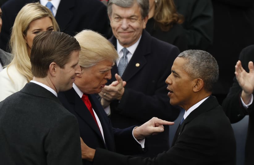 Donald Trump speaks to Barack Obama at Trump's presidential inauguration in Washington, US, January 20, 2017 (photo credit: KEVIN LAMARQUE/REUTERS)