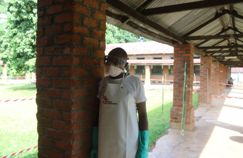 A health worker prepares to takes off protective clothing after visiting the isolation ward at Bikoro hospital, which received a new suspected Ebola case, in Bikoro, Democratic Republic of Congo May 12, 2018. (photo credit: JEAN ROBERT N'KENGO/ REUTERS)