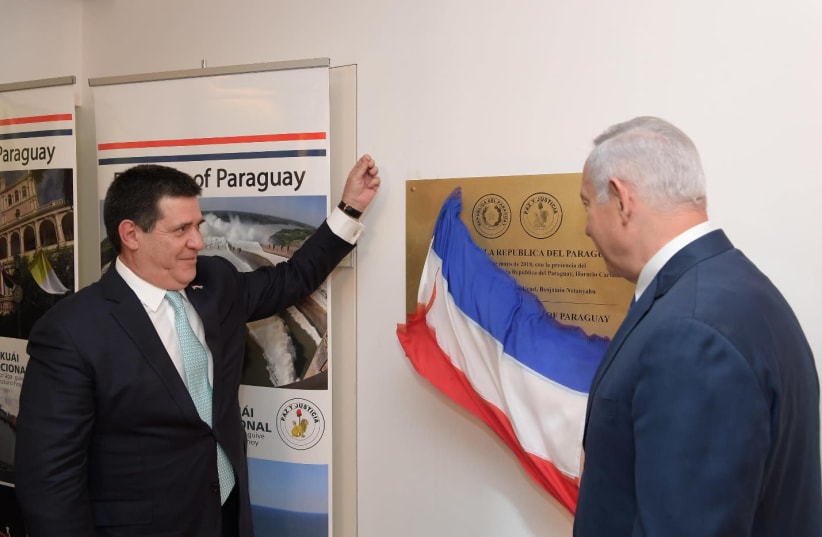 Prime Minister Benjamin Netanyahu (R) and Paraguayan President Horacio Cartes (L) unveil the new Paraguayan embassy in Jerusalem, May 21, 2018. (photo credit: AMOS BEN-GERSHOM/GPO)