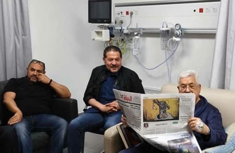Mahmoud Abbas reads a newspaper in a hospital in the Palestinian city of Ramallah (photo credit: Courtesy)