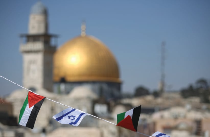 PALESTINIAN AND Israeli flags fly over the Western Wall and the Dome of the Rock (photo credit: MARC ISRAEL SELLEM)