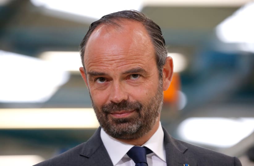 French Prime Minister Edouard Philippe listens to a speech about the government's recycling program during a visit at the Groupe Seb Moulinex factory in Mayenne, France, April 23, 2018. (photo credit: STEPHANE MAHE / REUTERS)