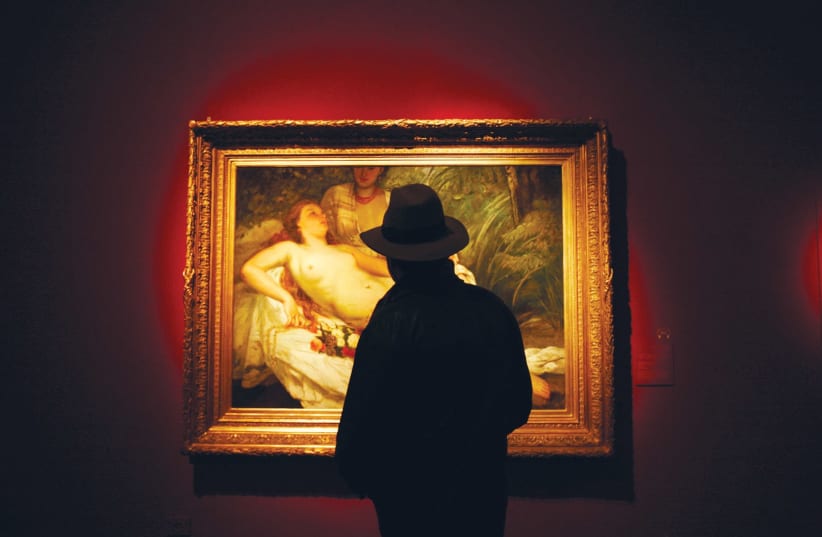 A MAN looks at a painting titled ‘The Bathers’ during a 2008 exhibition devoted to finding owners of paintings looted by the Nazis. (photo credit: REUTERS)