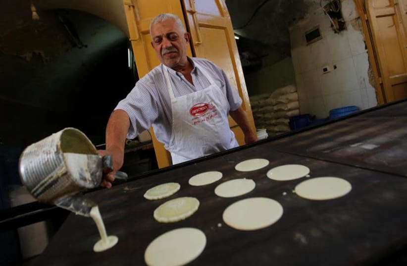 Traditional pastries being prepared ahead of the month of Ramadan in the Hebron May 16, 2018 (photo credit: REUTERS/MUSSA QAWASMA)