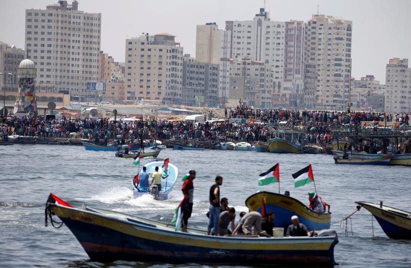 People watch as a boat prepares to set sail in attempt to break Israel's maritime blockade on Gaza, May 29, 2018. (photo credit: REUTERS/MOHAMMED SALEM)