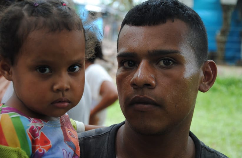 Ivan Carranza, 24, with his daughter, Maikelis, immigrants from Venezuela (photo credit: COURTESY CADENA)
