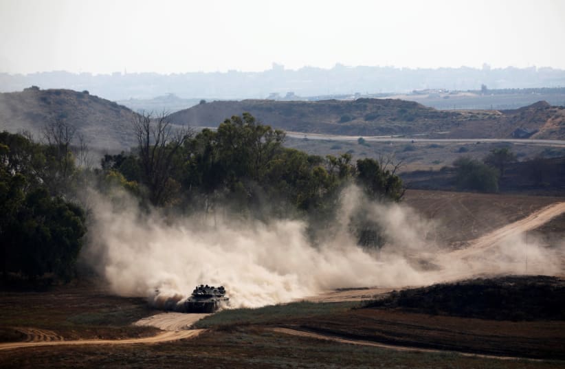 An Israeli tank drives on the Israeli side of the border between Israel and Gaza (photo credit: AMIR COHEN/REUTERS)