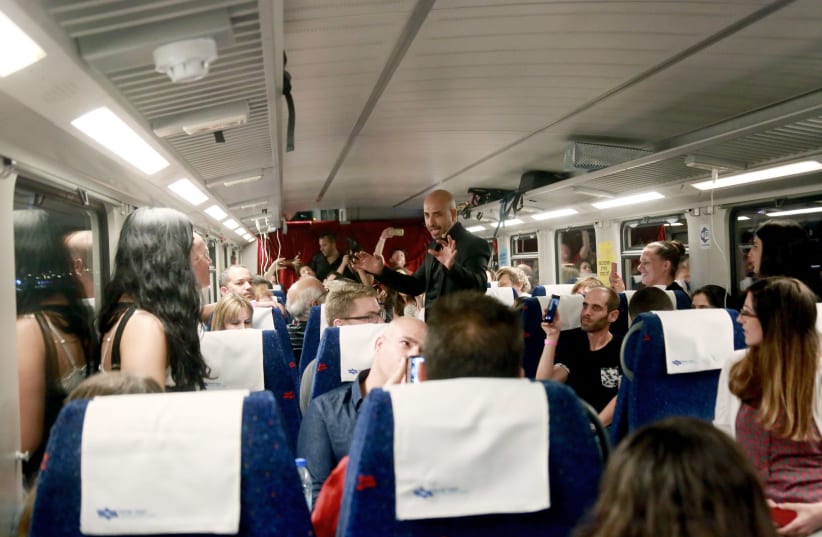 Magician Hezi Dean does magic for passengers on a train ride to Tel Aviv. (photo credit: SARAH LEVI)