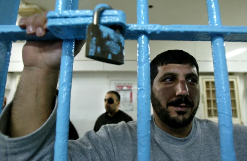 A Palestinian prisoner, convicted of security offences against Israel, looks out of his cell at Nitzan jail (photo credit: REUTERS/NIR ELIAS)