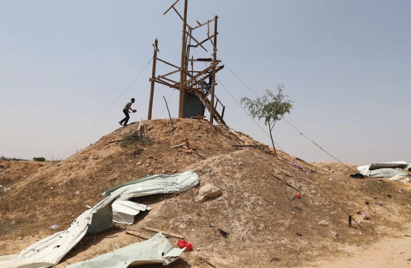 PALESTINIANS INSPECT an Islamic Jihad observation post after it was targeted in Israeli tank shelling, in the southern Gaza Strip, May 2018. (photo credit: IBRAHEEM ABU MUSTAFA/REUTERS)
