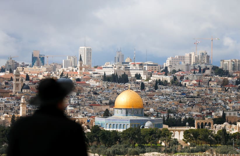 An ultra-Orthodox Jewish man is seen in the foreground as the Dome of the Rock is seen in the background February 15, 2017 (photo credit: REUTERS/AMMAR AWAD)