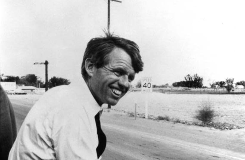 Robert F. Kennedy sits alongside the motorcade in this 1968 file photograph. (photo credit: REUTERS/STRINGER)