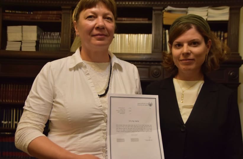 Zvia Gordestski (left) holding the rabbinical court document freeing her from her marriage, alongside Center for Women’s Justice attorney Nitzan Caspi-Shiloni (photo credit: CENTER FOR WOMEN’S JUSTICE)