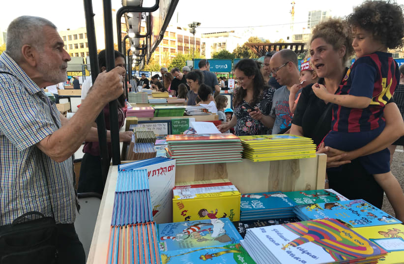 Readers check out this year's selection of books at Tel Aviv's Book Week at Rabin Square on June 6, 2018 (photo credit: Courtesy)