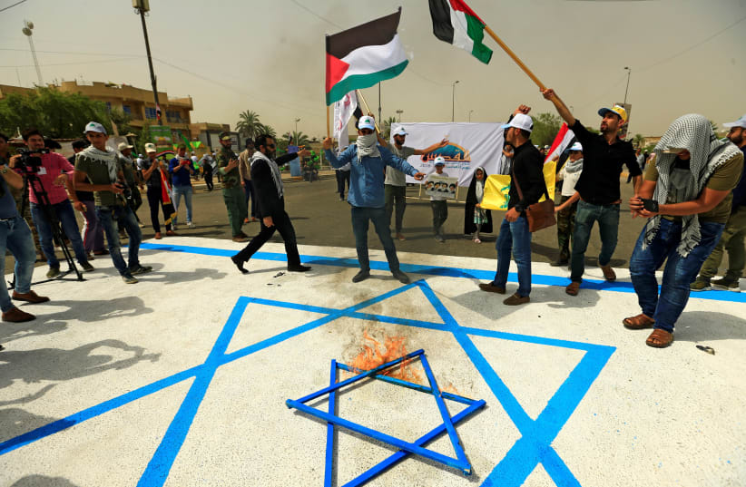Iraqi Shi'ite Muslims burn a Star of David during a parade marking the annual al-Quds Day, (Jerusalem Day) on the last Friday of the Muslim holy month of Ramadan in Baghdad, Iraq June 8, 2018. (photo credit: THAIER AL-SUDANI/REUTERS)