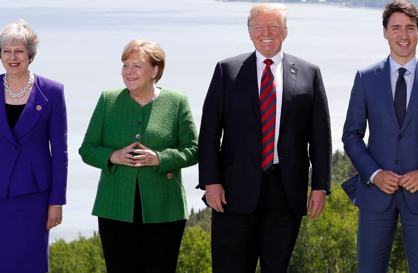 Britain's Prime Minister Theresa May, Germany's Chancellor Angela Merkel, US President Donald Trump and Canada's Prime Minister Justin Trudeau pose during a family photo at the G7 Summit in the Charlevoix city of La Malbaie, Quebec, Canada, June 8, 2018 (photo credit: YVES HERMAN / REUTERS)