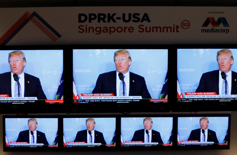 A TV news reports about U.S. President Donald Trump is projected on TV sets at a media center for the summit between the U.S and North Korea in Singapore (photo credit: REUTERS/KIM KYUNG-HOON)