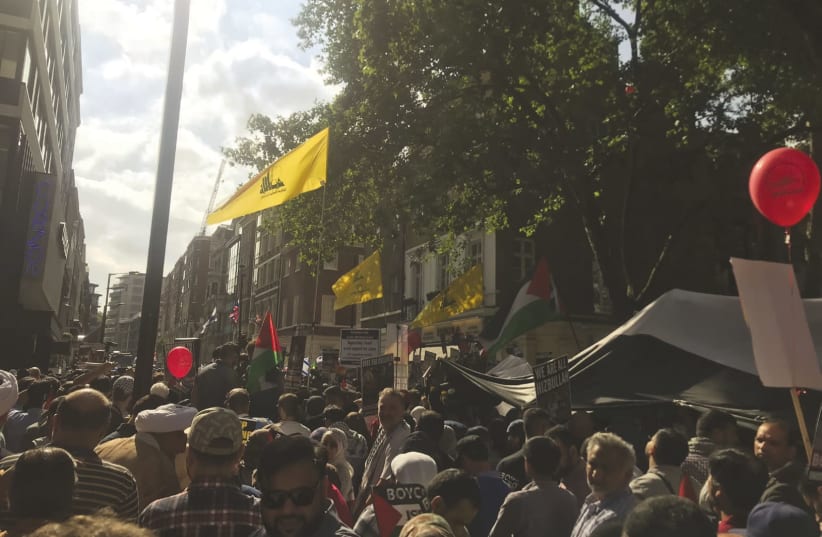 DEMONSTRATORS FLY flags of the Hezbollah terrorist group at a Quds Day march in London, June 10, 2018 (photo credit: JOSH DELL)
