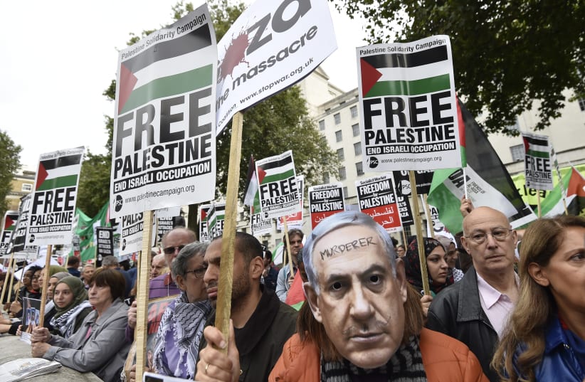 A demonstrator wears a Benjamin Netanyahu mask with a message written on it during a protest outside Downing Street in London, Britain September 9, 2015 (photo credit: REUTERS/TOBY MELVILLE)