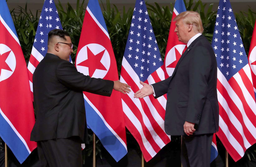 U.S. President Donald Trump shakes hands with North Korean leader Kim Jong Un at the Capella Hotel on Sentosa island in Singapore June 12, 2018.  (photo credit: JONATHAN ERNST / REUTERS)
