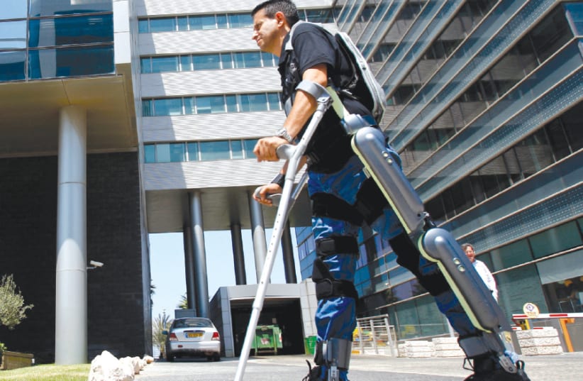 A MAN walks using ReWalk, an electronic exoskeleton, at a development center in Haifa (photo credit: BAZ RATNER/REUTERS)
